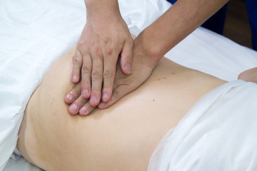 Fototapeta na wymiar A woman taking a treatment of alternative medicine. Belly massage. Close up