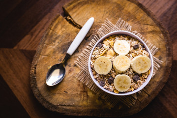 Bowl of cereal with fruit, pieces of banana with oats and cereal.