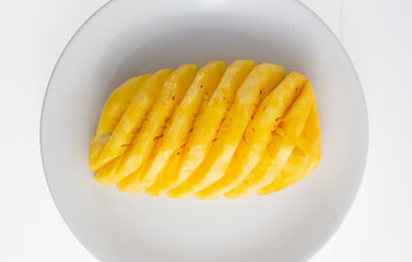 peeled pineapple on white plate
