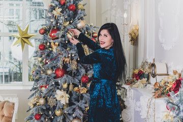 Elegant woman near christmas tree in cozy interior, holly christmas eve, magic new year with gifts...