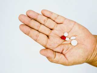 hand of the old woman with pills.white background.