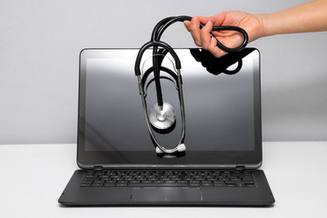 Woman's hand is holding stethoscope on the screen