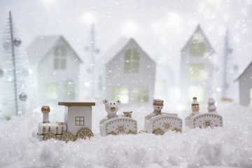 New Year card with toy train in a fairy villageon winter background with snow and lights. Template, greeting card