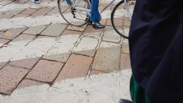Pedestrians crossing cobblestone road on zebra, compliance with traffic rules
