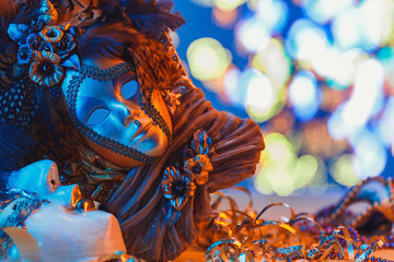 Fototapeta na wymiar Traditional female carnival venetian mask on blue bokeh background. Masquerade, Venice, Mardi Gras, Brazil festival concept