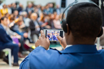 man taking photo on smartphone at a meeting
