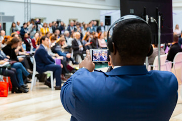 man taking photo on smartphone at a meeting