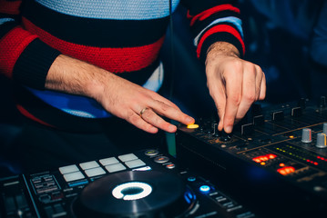 DJ in a booth playing a mixer at a nightclub at a party