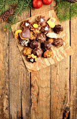 View from above of christmas sweets with different types of candy on baking paper on rustic wooden table