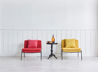 Red and yellow chair black coffee table and white wall.