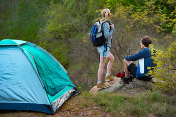 Attractive young couple camping trip in forest. Travel, tourism, hike and people concept.