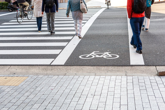 Crosswalk for people crossing on asphalt road with white bicycle symbol Traffic lane on asphalt road.