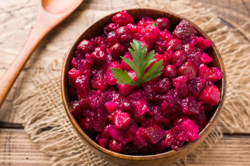 Fresh homemade beet salad vinaigrette in a wooden bowl. Traditional Russian food.