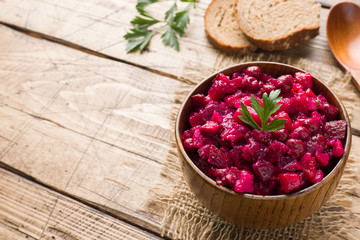 Fresh homemade beet salad vinaigrette in a wooden bowl. Traditional Russian food. Copy space