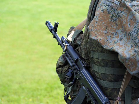 Shooting weapon, special operations forces combat. Army soldier with assault rifles and in bulletproof vests are on natural green military background