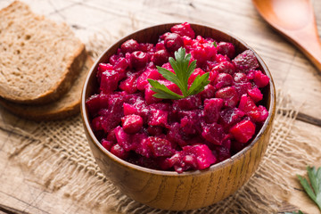 Fresh homemade beet salad vinaigrette in a wooden bowl. Traditional Russian food.