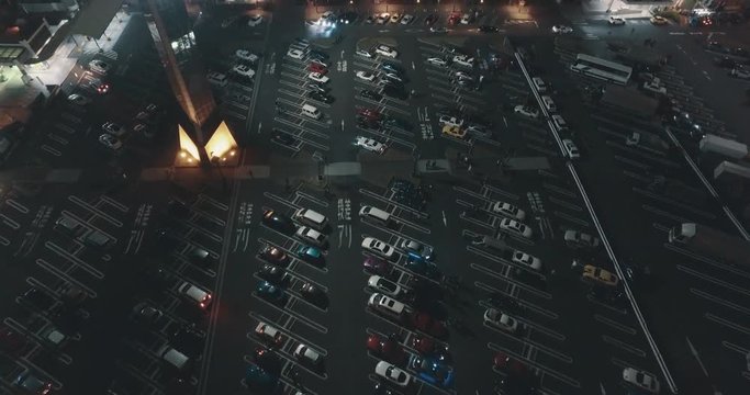 Aerial Drone Shot Pulling Up to Reveal an Orderly Tokyo Japan Parking Deck Area at Night Time.