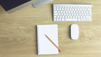 Computer keyboard, mouse and notebook with a pencil on the table
