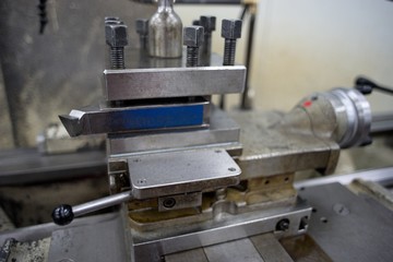 Lathe machine for metal cutting, machinery center background.