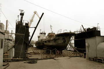 Archive 2008 River port of Ust-Danube was destroyed in of crisis. Old rusty boats on stocks in dry dock of river port. Old river vessels rust on dock repair shop stocks for repair of river vessels