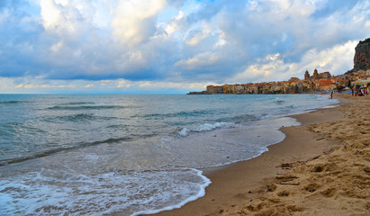 the beach of old coastal mediterranean town Cefalu with turquoise sea water and cloudy summer day,  Cefalu, Sicily Italy