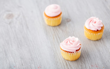 Tasty cupcake on wooden background. Birthday cupcakes on gray wooden background. Space for Text. Three cupcake.