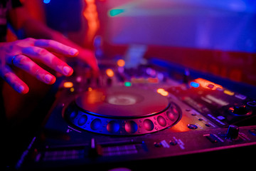 Fototapeta na wymiar Dj playing the track in the nightclub at party closeup