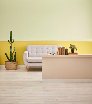 Decorative modern home with sofa cactus and book ornaments, yellow green background.