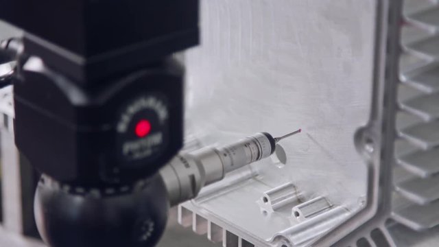 Macro footage of a coordinate measuring machine CMM measuring metal part