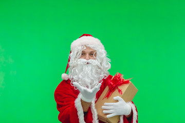 Photo of kind Santa Claus giving xmas present and looking at camera. chroma key