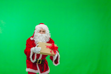 Photo of kind Santa Claus giving xmas present and looking at camera. chroma key