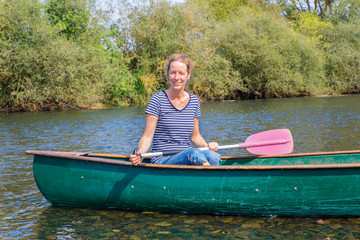 Dutch woman with paddle in canoe on river