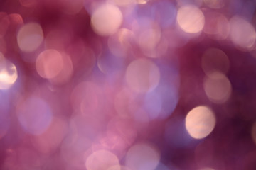 Fototapeta premium Bokeh photo. Holiday background. Christmas lights. Defocused sparkles. New Year backdrop. Festive wallpaper. Blinks. Carnival. Bokeh retro style photo. Pink.