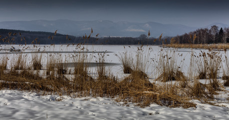 Snow covered frozen lake, wintertime in Diosjeno, Hungary