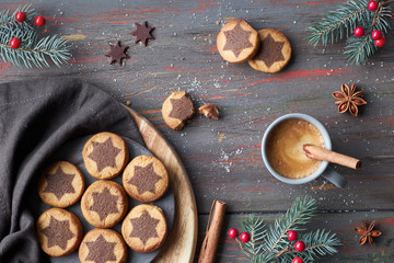 Christmas cookies with chocolate star pattern with espresso, cinnamon and decorated fir twigs