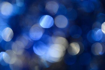 Bokeh photo. Holiday background. Christmas lights. background. Defocused sparkles. New Year backdrop. Festive wallpaper. Blinks. Carnival. Retro style photo. Blue.