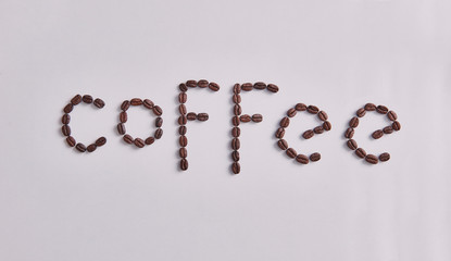 Coffee write with coffee beans on the white table