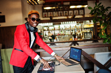 Fashion african american man model DJ at red suit with dj controller.