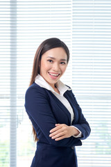 Portrait of smiling asian businesswoman standing in bright office