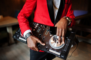 Hands of fashion african american man model DJ at red suit with dj controller.