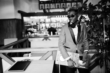 Fototapeta na wymiar Fashion african american man model DJ at red suit with dj controller.