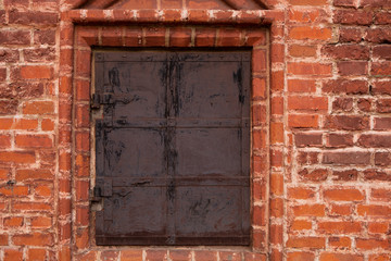 Obraz na płótnie Canvas Background or Brickwork Texture Of Old Vintage Dirty Red Or Brown Brick Wall With Window With Metal Shutters, Texture. Shabby Building Facade, Abstract Web Banner. Copy Space.