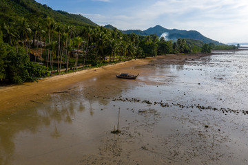 Aerial view of a small tropical beach surrounded by lush foliage and jungle (Koh Yao Noi, Thailand)
