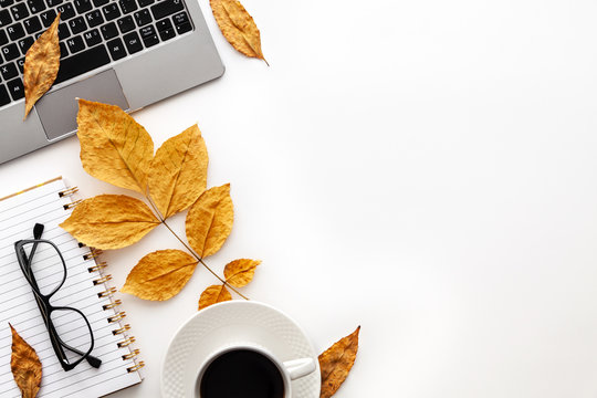 White autumn empty copy space with laptop, coffee, glasses, notebook and yellow leaves. Top view. Concept desk - Powered by Adobe
