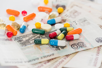 close up shot of colorful various pills and russian cash money on surface