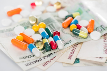 selective focus of colorful various pills and russian cash money on surface