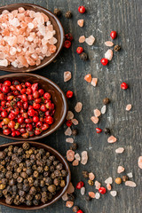 Close up pink himalayan salt and peppers in spoons