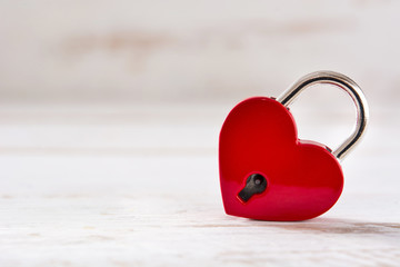 Red padlock hearts on white wooden background. Copyspace