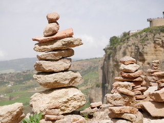 Pile of orange stones in perfect balance on a cliff in the mountains of Ronda, Spain