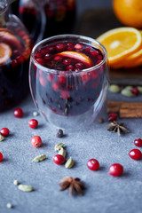 close up of tasty homemade mulled wine with cranberries and oranges on table in kitchen